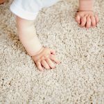hands of baby crawling on floor or carpet